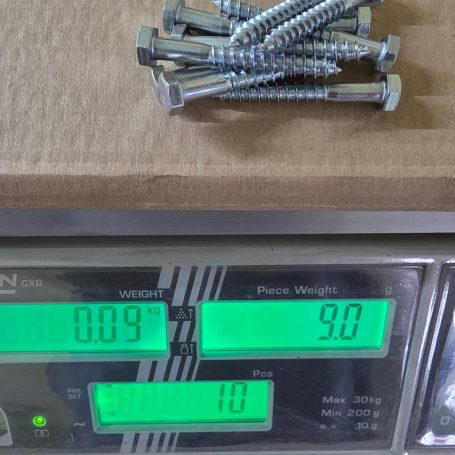 Schrauben auf einer Waage mit angezeigtem Gewicht und Stückzahl.