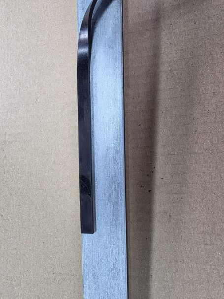 Graue Metallplatte mit schwarzem Griff an der Seite.